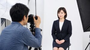 証明写真の撮影シーンでスーツ姿の女性が微笑んでいる様子