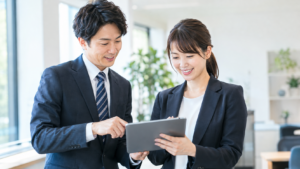 タブレットを一緒に見るビジネスパーソンの男女