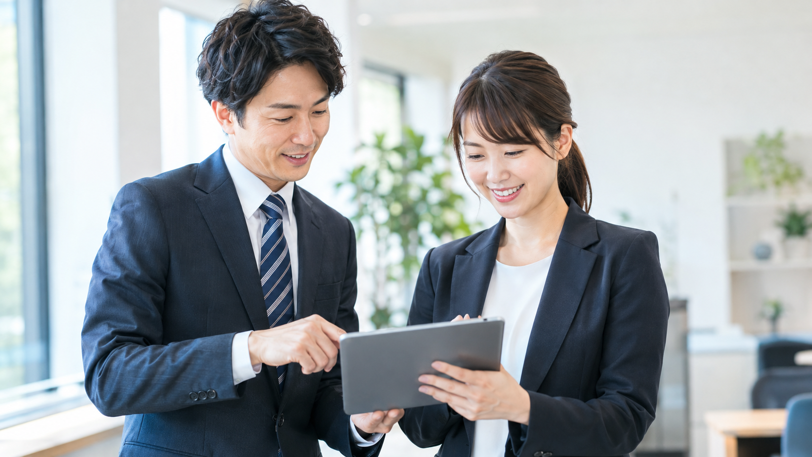 タブレットを一緒に見るビジネスパーソンの男女